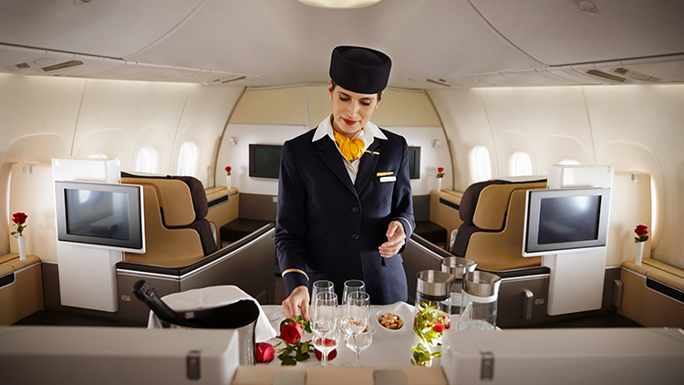 A cabin attendant prepares snacks and drinks for first class on an aircraft