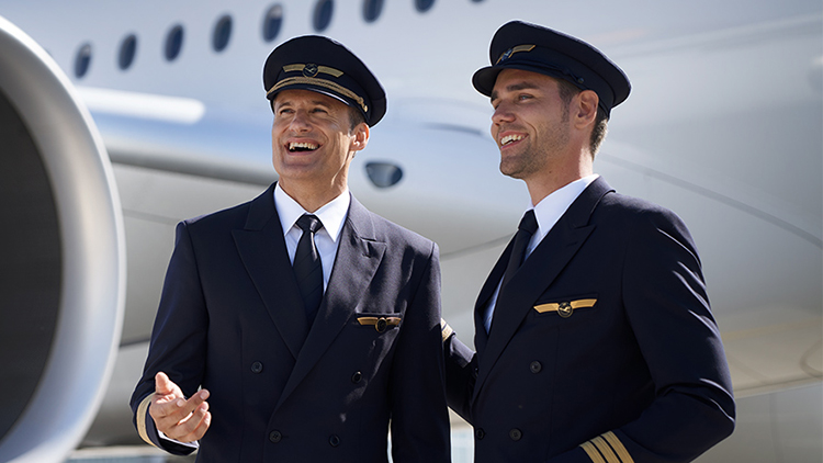 Two laughing pilots standing in front of a plane