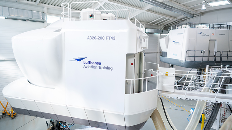 Two flight simulators from Lufthansa Aviation Training are located in a hangar.