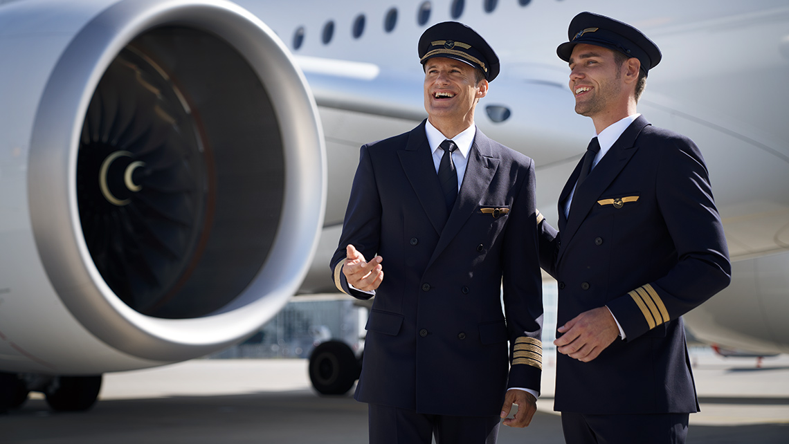 Two laughing pilots standing in front of a plane