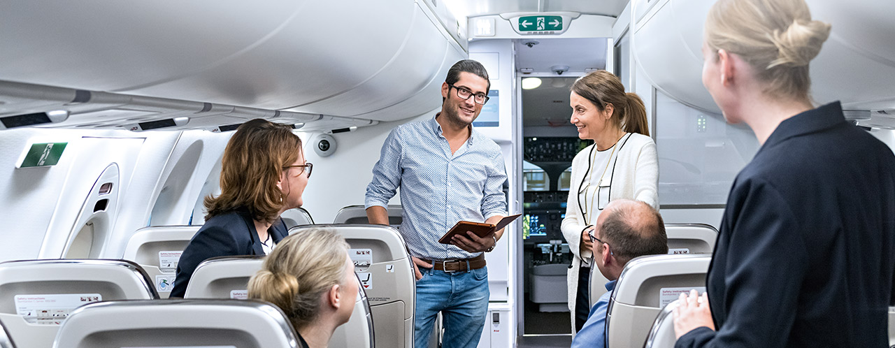 Eine Gruppe mit Trainingsteilnehmern in einer Flugzeugkabine