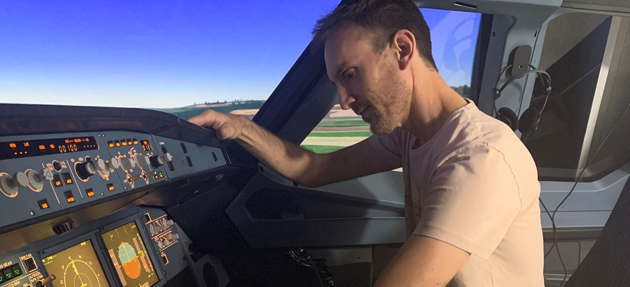 A person is sitting in a flight simulator.