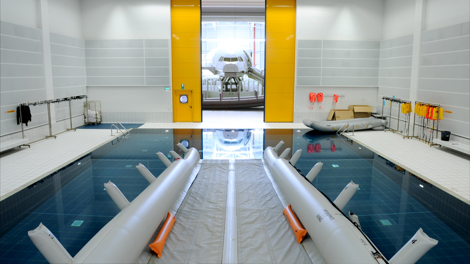 In a training hall, a rescue chute runs into a water basin