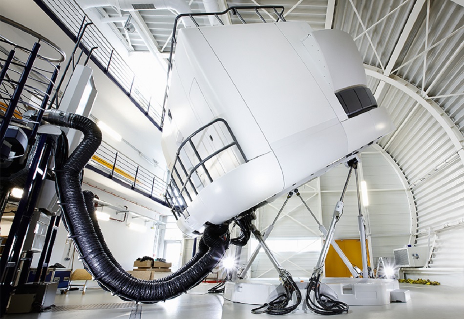 A full flight simulator in motion inside a hall.