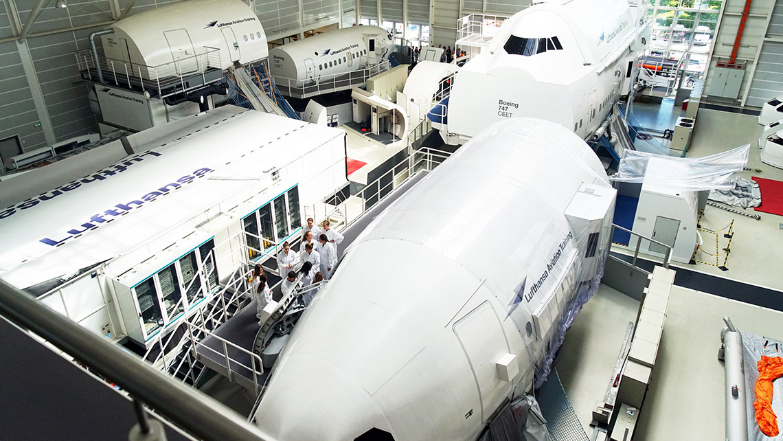 Several Cabin Emergency Evacuation Trainer (CEET) from Lufthansa Aviation Training are located in a hangar.